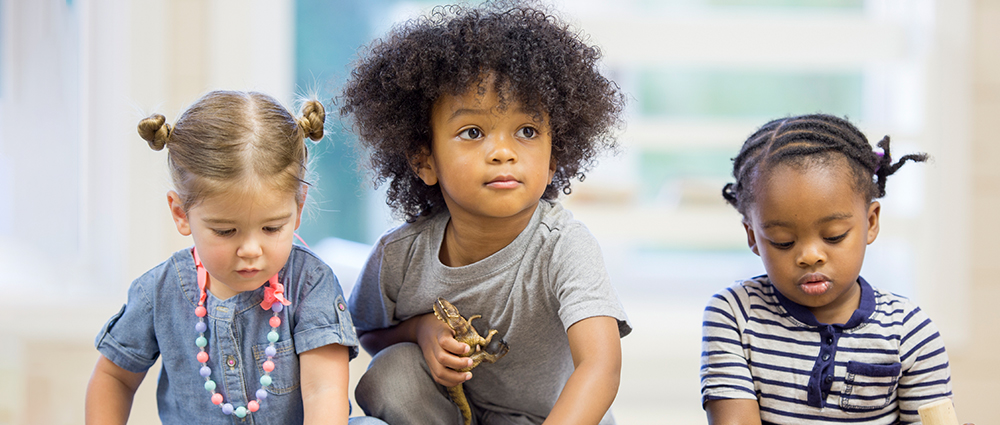 three small children playing with toys