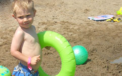 Young boy at beach floating tube
