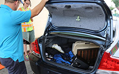 Removing waste items from trunk of car