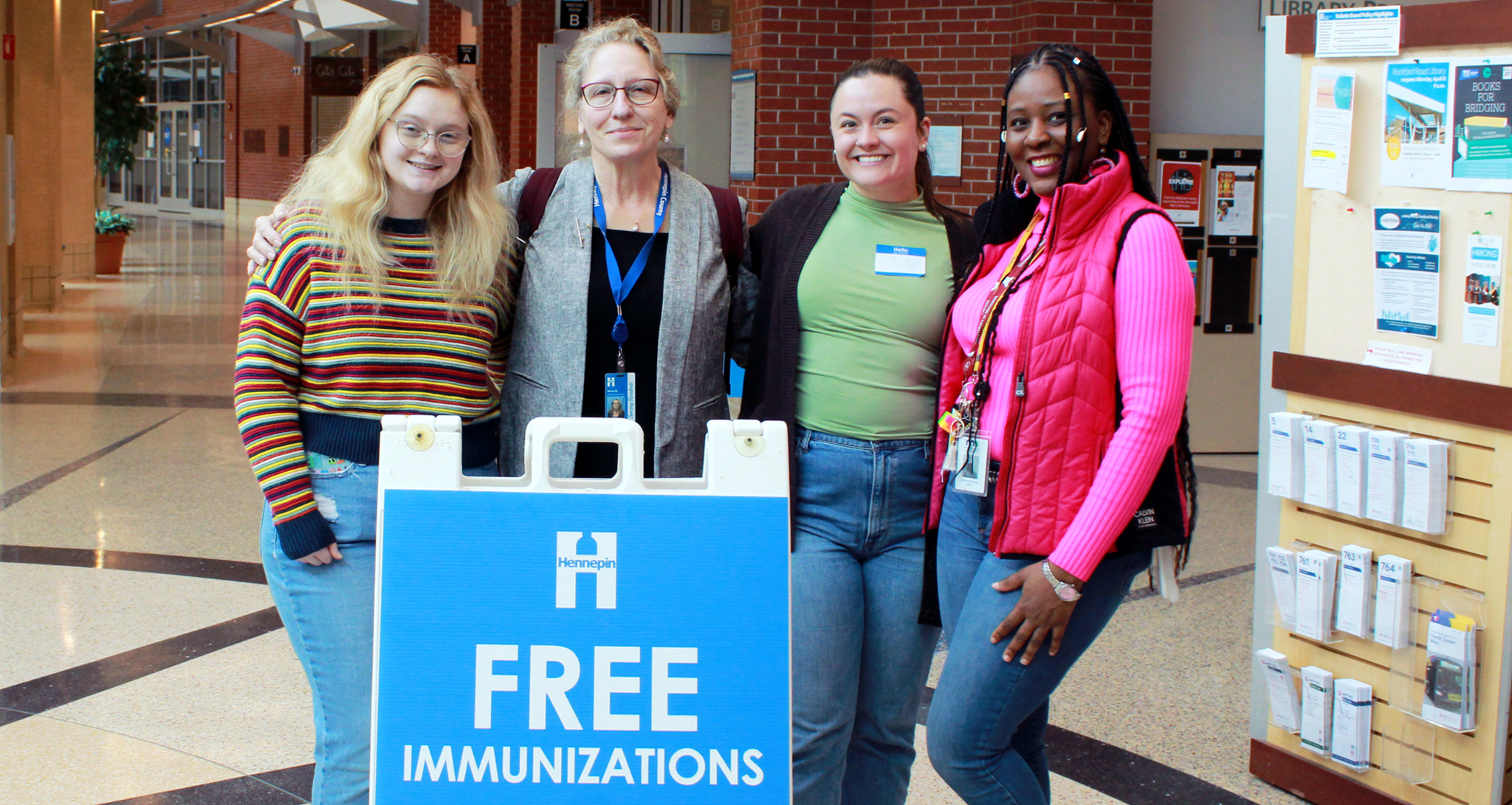 Women in front of free immunizations sign