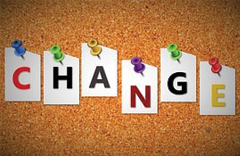 corkboard with paper pinned with thumbtacks spelling out the word change