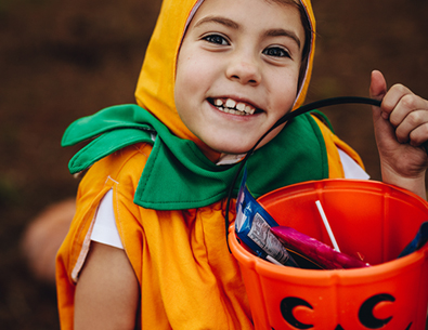 kid in a costume holding a halloween bucket