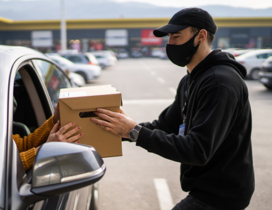 man delivering a package to a car