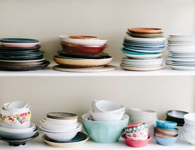 Stacks of mismatched plates and bowls from thrift store