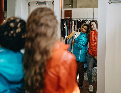 two women checking out clothes in a mirror