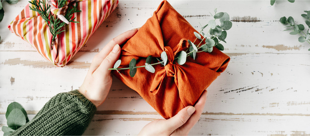 Close up of hands holding a present wrapped in cloth