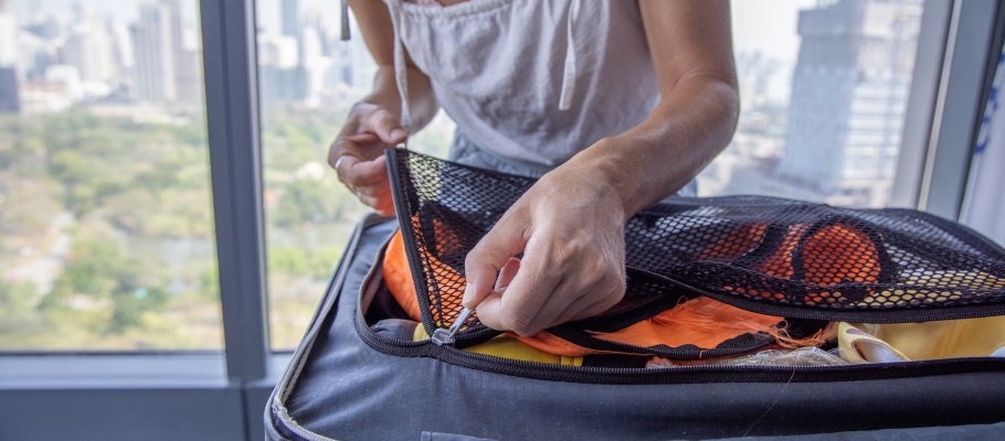 Woman zipping closed a suitcase with a separated zipper