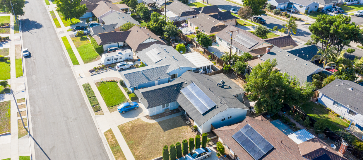 Overhead view of homes on a suburban street with solar panels on the roofs