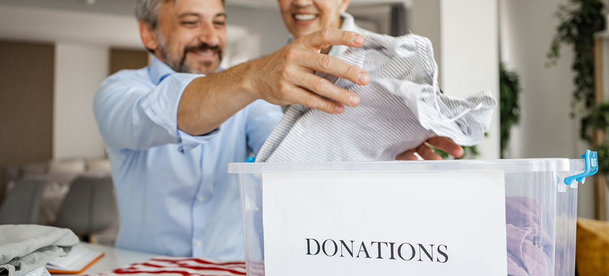 Man putting items in a box labeled "donate"