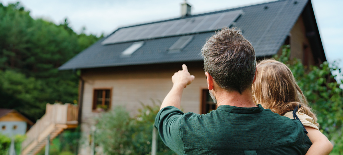 Man pointing at solar panels on roof