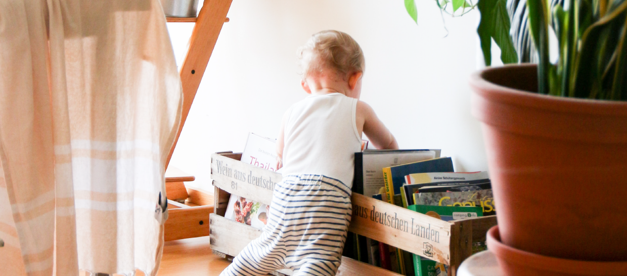 Toddler playing with books on the ground