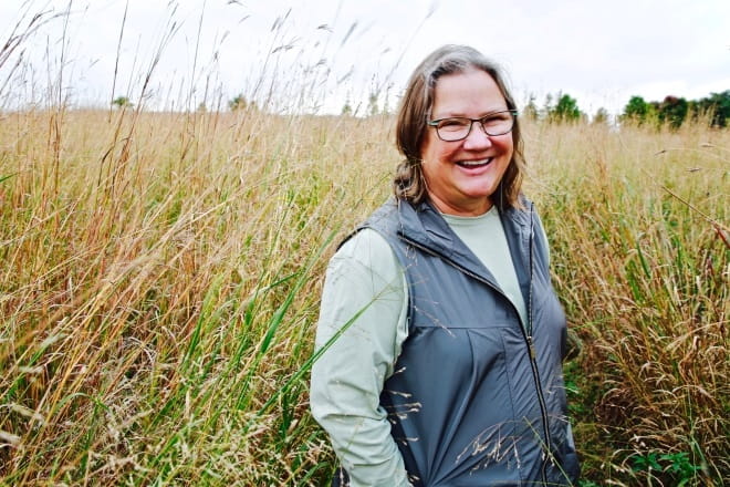 Woman standing in field of tall prairie grass
