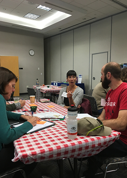 Three people sitting around a table in a conference room having a conversation