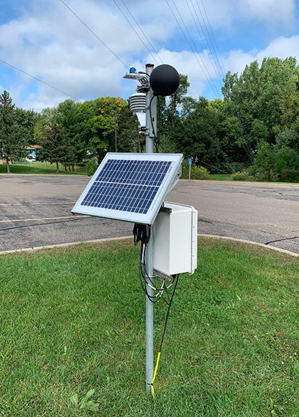 Mesonet station with a black globe sensor and small solar panel