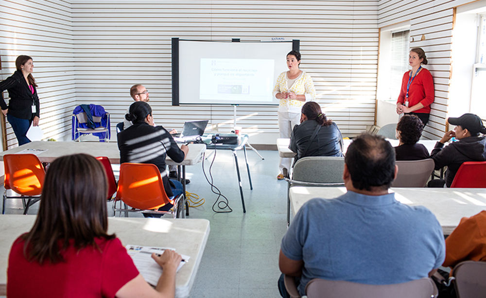 Woman standing at front of room giving a presentation