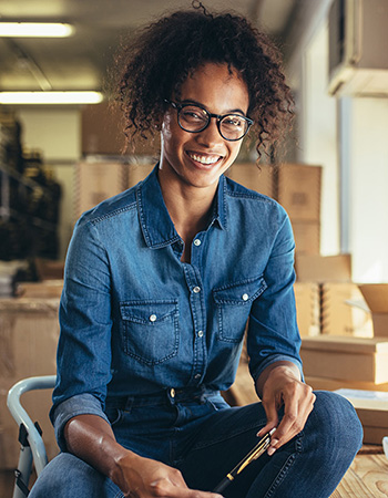 A woman sitting in her new business after completing CEO Start and validating her business idea. 