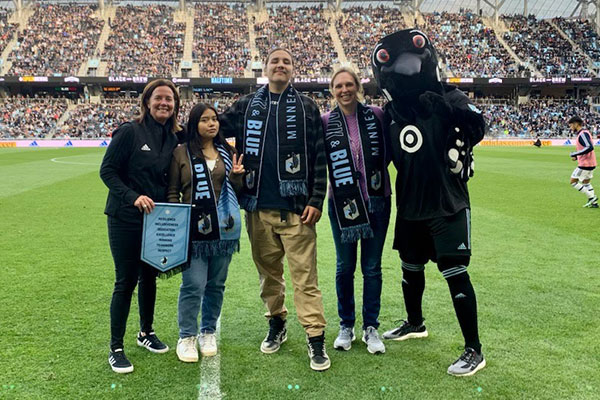 two youth partners from Indigenous Peoples’ Task Force are honored at a Minnesota United game